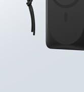 Close-up of a black electronic device, showing part of its body and a strap or cable. Appears to be a partial view of a portable speaker or similar gadget.