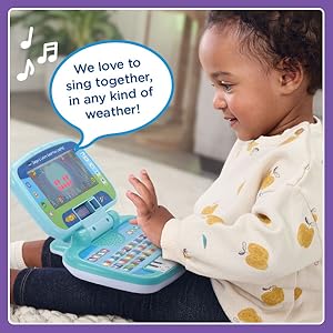 Girl pushes button. Toy laptop: We love to sing together in any kind of weather!