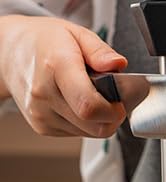 Close-up shot of hands using what appears to be a small handheld tool or device against a blurred background.