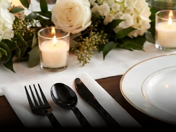 On a table lay exquisite tableware and black plastic cutlery