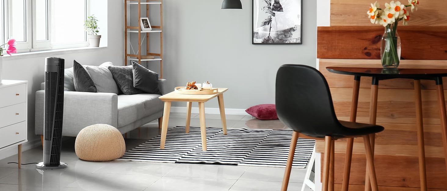 Black tower fan in modern style living room, next to grey couch