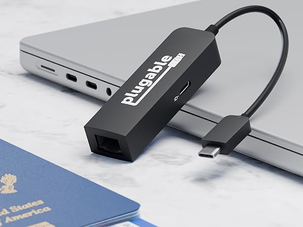Plugable USB C 2.5Gbps ethernet adapter with pass through charging resting on laptop