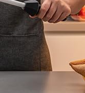 Close-up of hands holding a dark gray textured object, possibly a bag or case, on a wooden surface.