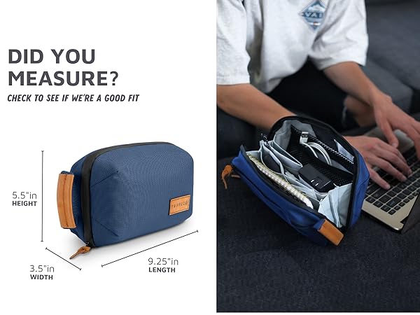 tech travel bag on a desk next to a laptop with product dimensions