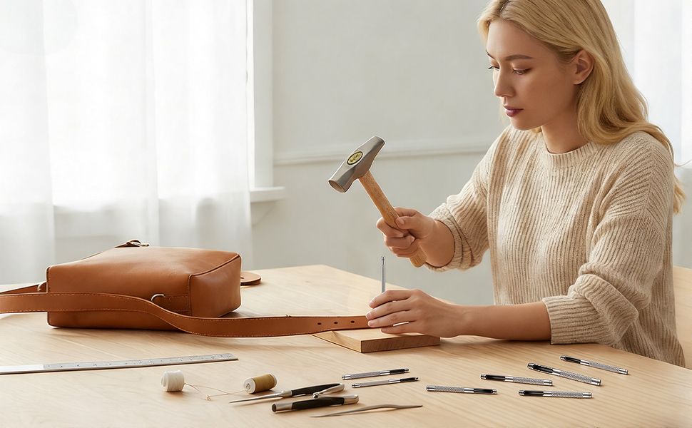 The woman is using a leather punching tool to process the leather for the bag strap