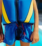 a child wearing a life jacket and blue shorts