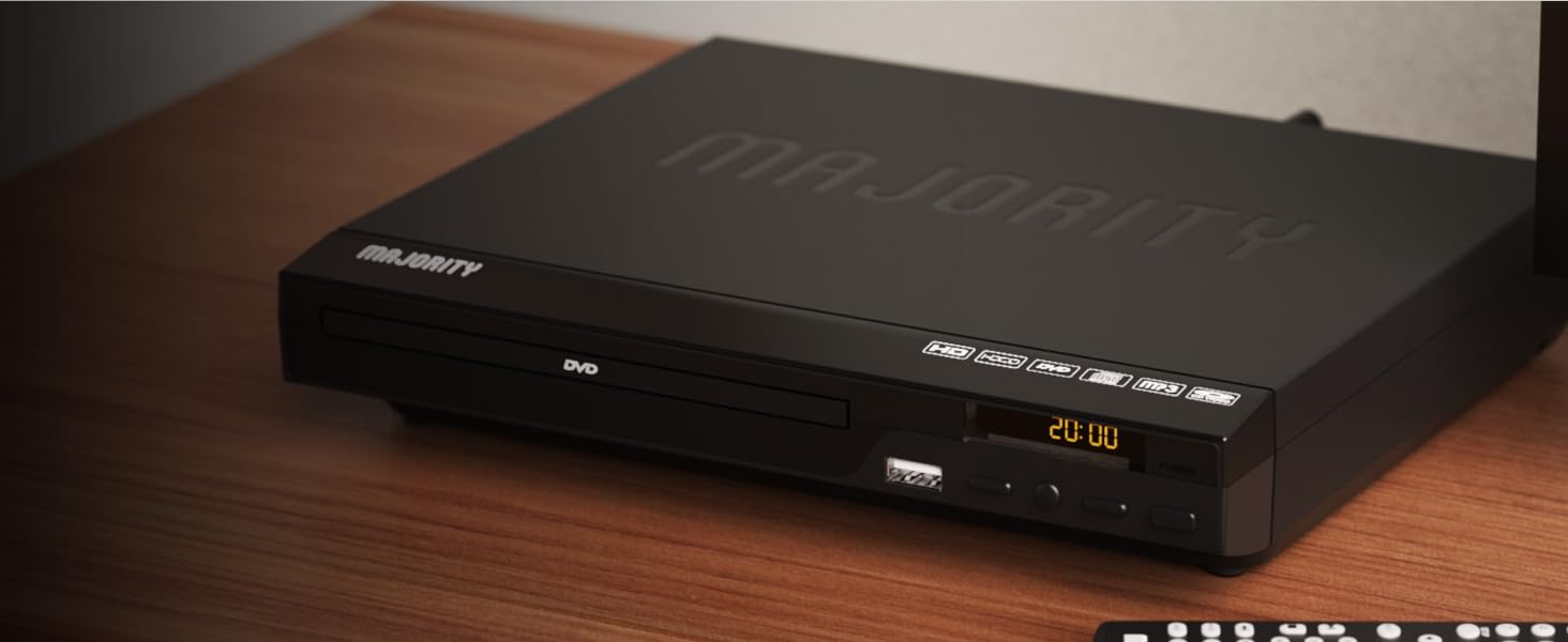 Majority region free dvd player on wooden shelf in living room. Display shows time