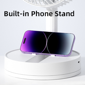 A white portable fan with a built-in phone stand holding a purple smartphone.
