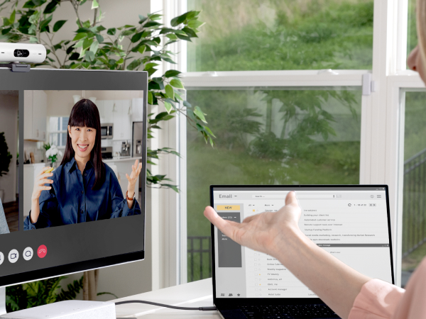 An angle image of a woman having a video call on a computer using Brio 500