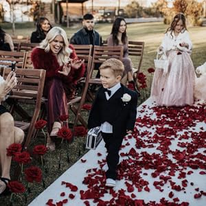 Ring bearer walking down the aisle holding a ring security case
