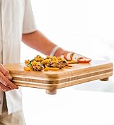 Totally Bamboo Big Easy Bamboo Wood Chopping Block carrying food.
