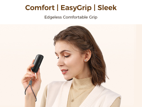 Man holding rechargeable hand warmer while working on laptop, compact pocket heater.