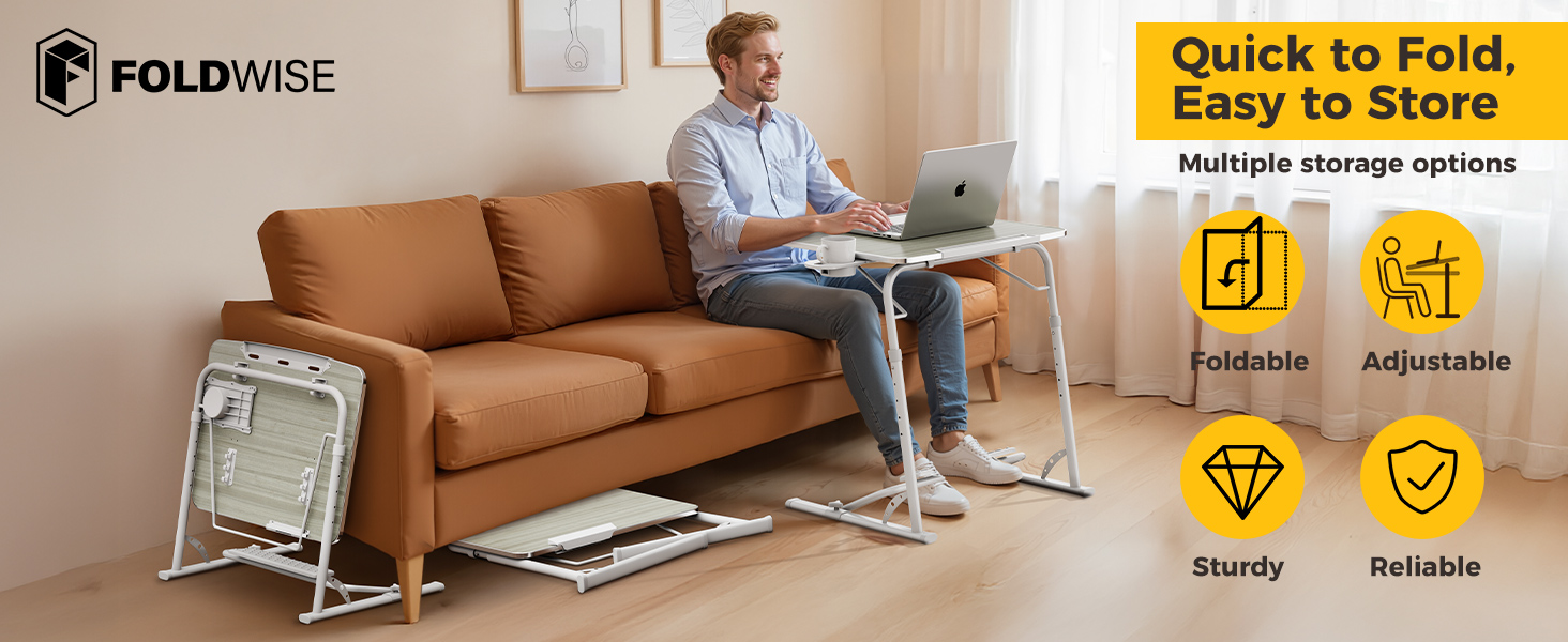 Man working on a couch using a foldable computer desk with stored folding tray tables nearby.