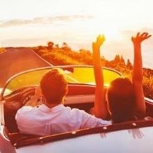 A person holding the Koolatron 12V cooler bag by the handles stepping into a pickup truck