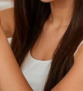 Person wearing white sleeveless top shown from shoulders down in cropped view against neutral background.