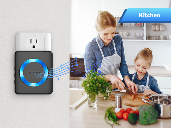 Wall-mounted smart plug with glowing blue ring. Kitchen scene shows adults preparing vegetables, demonstrating the plug's potential use in appliance control.