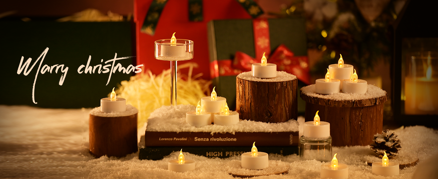 Christmas scene with various illuminated flameless candles. Candles are placed on wood slices, books, and in snow, creating a warm, festive atmosphere. Text 'Merry christmas' visible.
