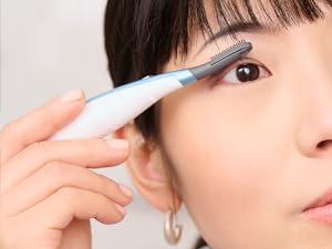 Woman using eyelash curler.