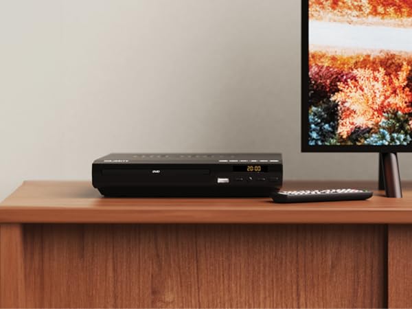 DVD player for smart tv with remote control standing on shelf in living room next to the tv.