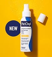 bottle of panoxyl antimicrobial purifying mist laying on a yellow background with cap off