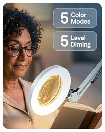 A woman doing detailed hobby work at a desk with a lighted magnifier on an adjustable arm.
