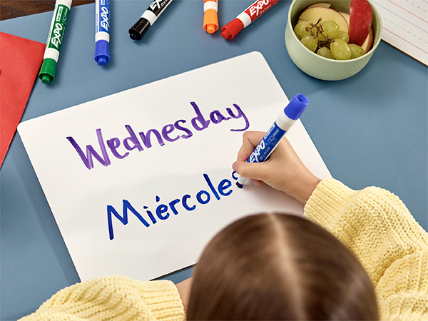 Girl writing on white board with marker