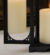 Close-up of black furniture legs or table base against a light-colored floor. Limited context for full product identification.