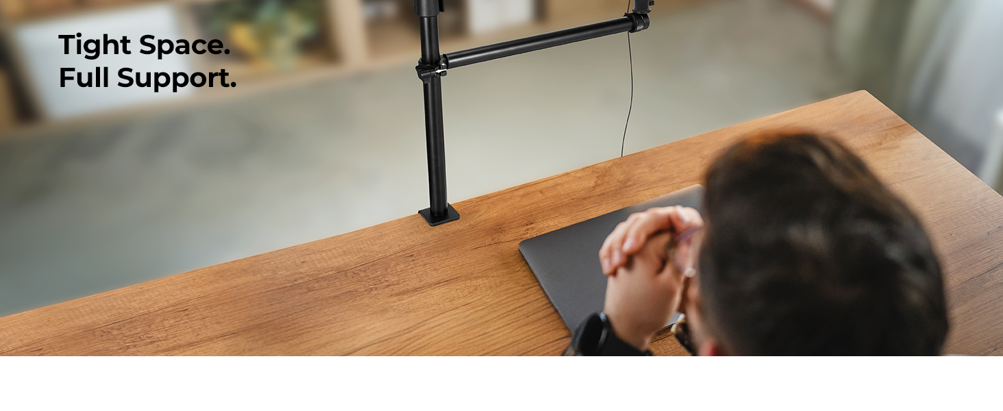 Text reads 'Tight Space, Full Support.' Professional workspace setup showing an articulating monitor mount attached to a wooden desk, demonstrating flexible positioning capabilities.