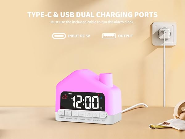 Text reads "TYPE-C &amp; USB DUAL CHARGING PORTS", "INPUT DC 5V", "OUTPUT". Pink and white digital alarm clock with LED display showing "12:00" features dual charging ports, photographed plugged into wall outlet with charging cable.