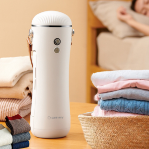 the clothes dryer is standing on a table with folded clothes and sock in a quite room
