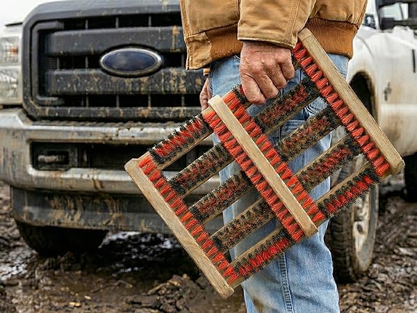 man holding portable lightweight shoe scrubber in front of truck in mud