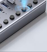 Close-up of a gray electronic device with multiple knobs and buttons visible, positioned on a white surface.