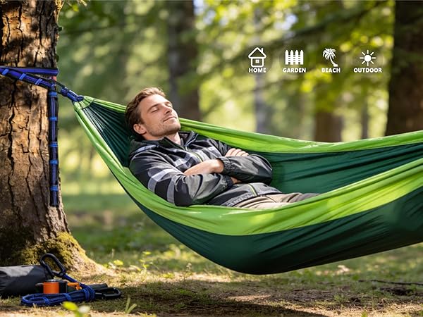 Person relaxing in green hammock suspended between trees in forest setting, with small icons visible in top right corner.