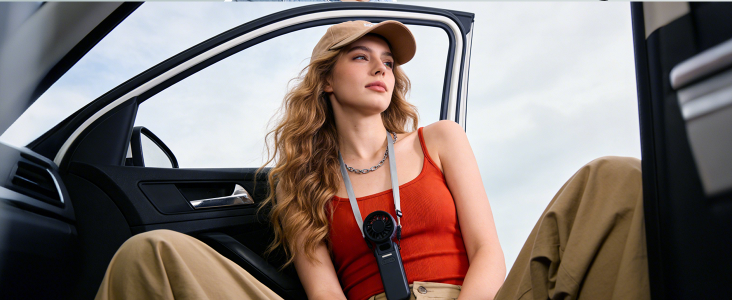 Woman with long reddish-brown hair wearing red sleeveless top and tan pants sitting in convertible car with door open, demonstrating usage context.