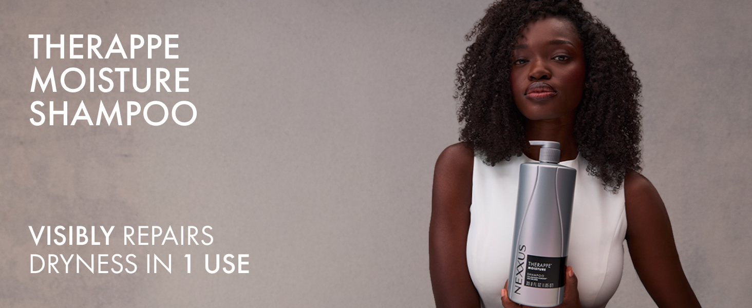Young woman with healthy curly dark hair holding a Nexxus Therappe Moisture Shampoo bottle.