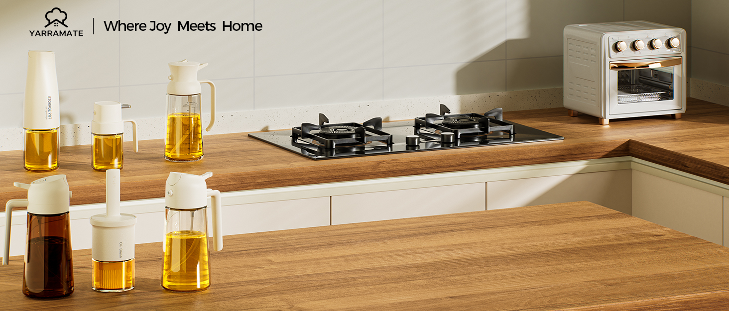 Kitchen countertop with gas stove, mini oven, and various glass containers filled with liquids. Wooden surface contrasts with white cabinets, showcasing modern kitchen design elements.