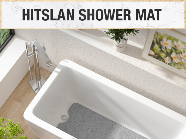 Text reads 'HITSLAN SHOWER MAT'. Shows a white bathtub with gray non-slip mat installed, photographed from above with bathroom decor visible.