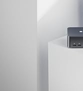 Partial view of a white wall corner with what appears to be a small dark device mounted at the top.