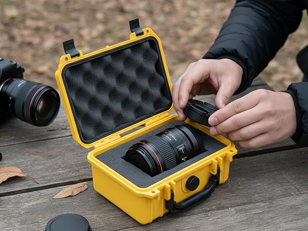 Yellow protective hard case being opened outdoors, containing camera equipment. Photography gear and camera visible in background.