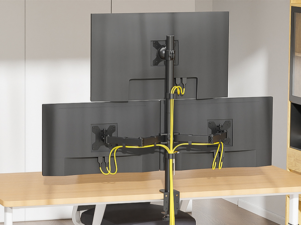 Triple monitor desk mount setup with adjustable arms and yellow cable management system, attaching three black monitors to a wooden desk surface.