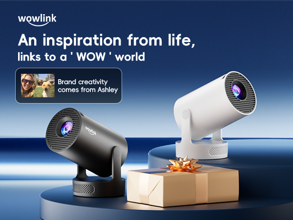 Two compact projectors, one black and one white, displayed on a blue surface. The devices feature circular lenses and adjustable bases, suggesting portable projection capabilities.