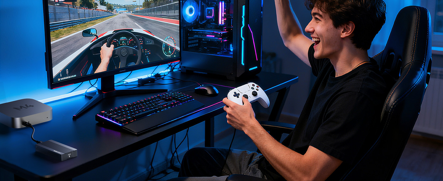 Gaming setup environment showing person at computer desk with multiple monitors, gaming controller, and blue ambient lighting.