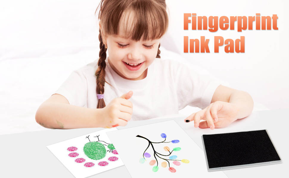 the little girl is drawing on the paper with her fingers.