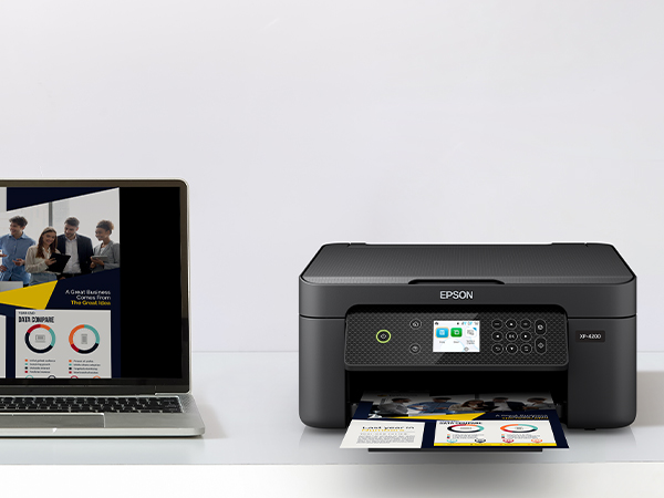 Black Expression Home XP-4200 on desk wirelessly printing content from laptop.