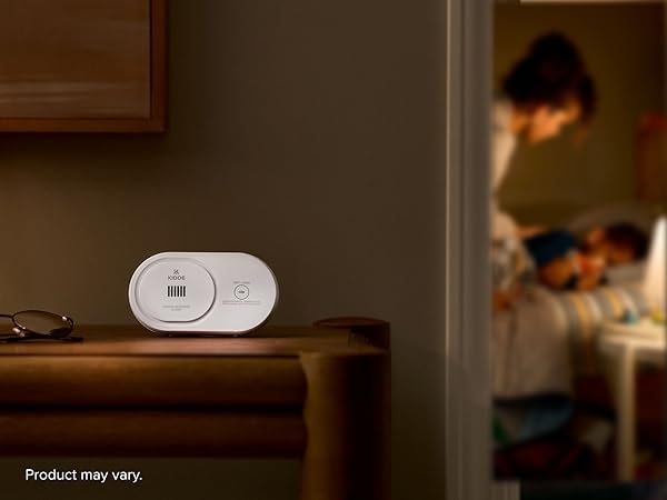 Kidde AA battery carbon monoxide detector sitting on table at nighttime, 10 year expiration, mobile