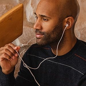 african american man wearing WHITE earbuds speaking to aN INLINE microphone