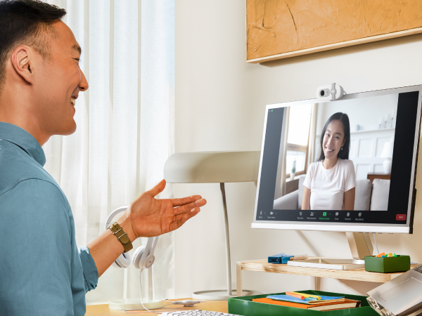 a man having a video call using brio 100 full hd webcam for meetings and streaming
