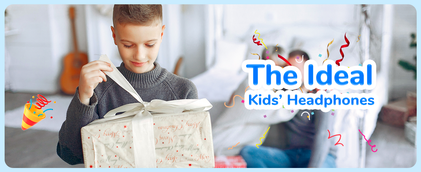 Young boy opening a large gift box wrapped in white paper with red designs. Text overlay reads 'The Ideal Kids' Headphones' with colorful party emojis.