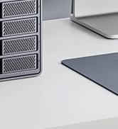 White plastic or metal component piece with angular cutouts and mounting points, appears to be part of a larger assembly.