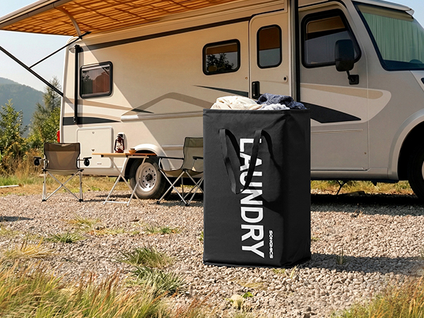 Multiple camping trailers or RVs parked in an outdoor setting with mountains visible in the background. Scene shows a recreational vehicle campground or park.